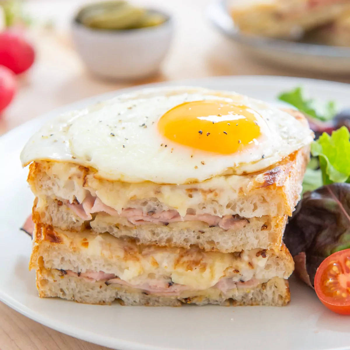 Croque madame - französische warme Sandwiches mit Eiern, Schinken und Béchamelsauce