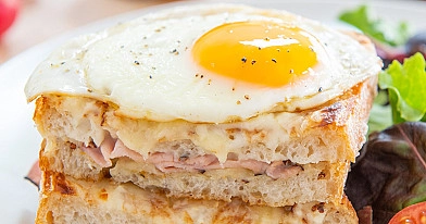 Croque madame - französische warme Sandwiches mit Eiern, Schinken und Béchamelsauce