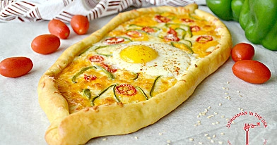 Türkische Pide-Pizza - Türkische Pide-Pizza mit Käse, Tomaten und Ei