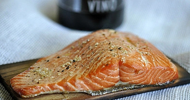 Lachs im Kamado-Grill auf Holzbrettern